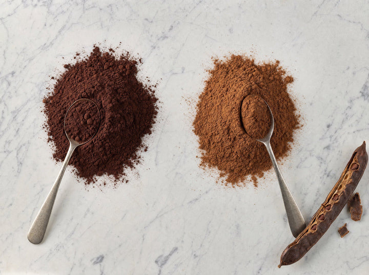 Zwei braune Pulverhäufchen nebeneinander: dunkler Kakao und helleres Carob