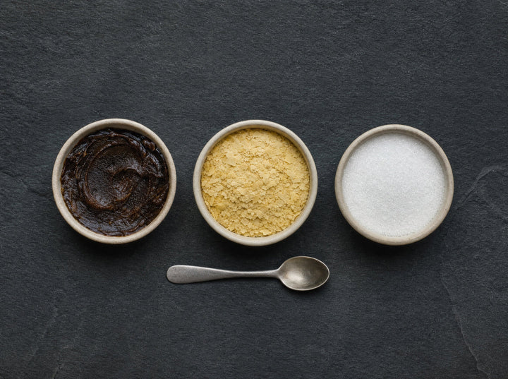 Drei Schälchen: dunkle Paste, helle Flocken, weißes kristallines Pulver