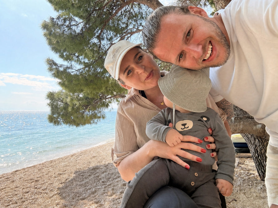Miriam, Kevin und ihr Sohn Liam am Strand unter einer Pinie