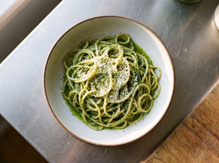 Bandnudeln mit cremigem grünem Basilikum-Pesto, Parmesan und gerösteten Kernen
