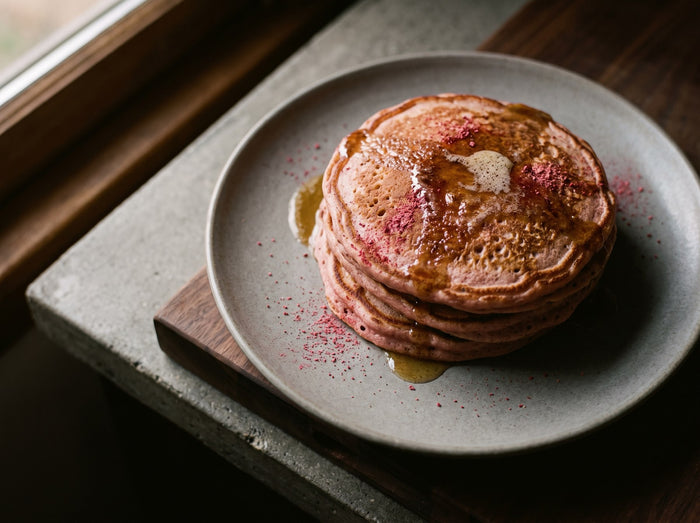 Rosa Ricotta-Pancakes mit brauner Butter, gestapelt auf einem Teller